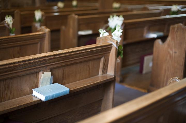 pews_and_bible.jpg - Closeup background image of wooden pews and a bible ready for prayer and worship in a small country church
