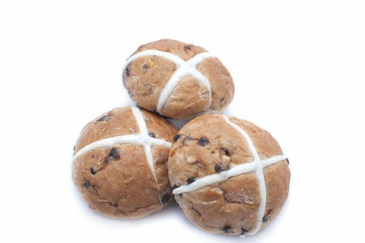 hot_cross_buns_isolated.jpg - Trio of freshly baked fruity Hot Cross Buns for Easter with their distinctive pastry cross commemorating the crucifixion over a white background with copy space