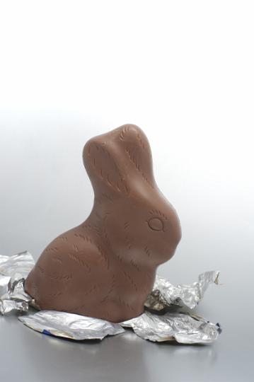 unwrapped_chocolate_rabbit.jpg - Unwrapped chocolate rabbit Easter egg standing sideways on its shiny silver foil wrapping