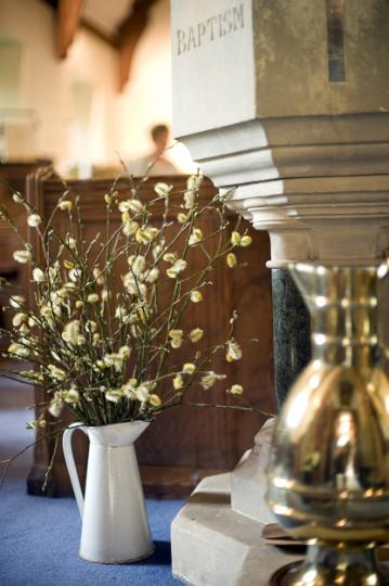 church_font.jpg - Background of a vase of spring flowers at the foot of a stone church font