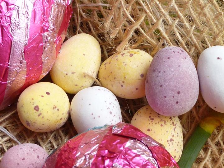 mini_eggs.jpg - Colorful sugar-coated mini Easter Eggs on rustic hessian to celebrate the holiday season